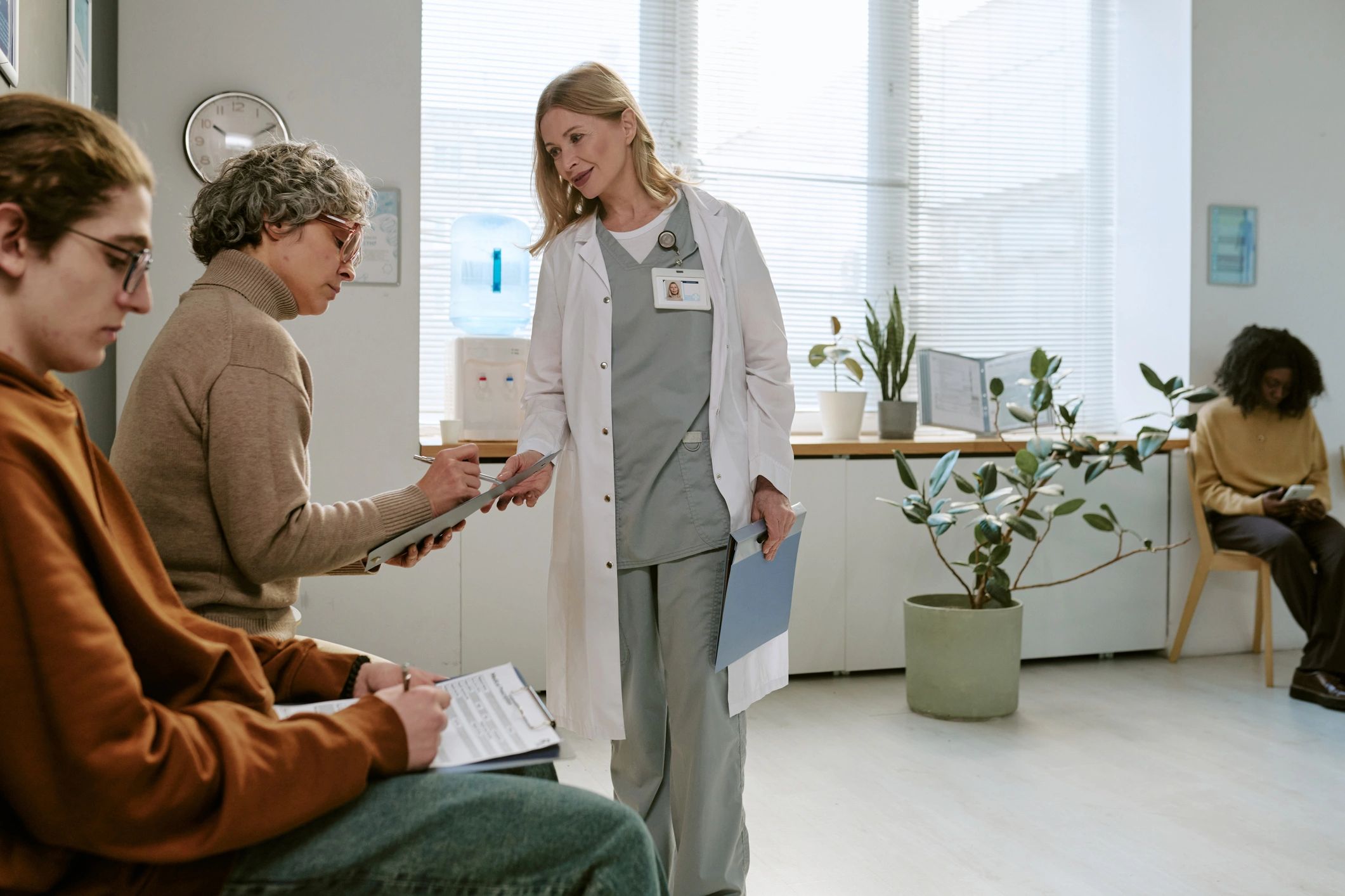 Doctor assisting patient with intake forms, representing operational process improvement