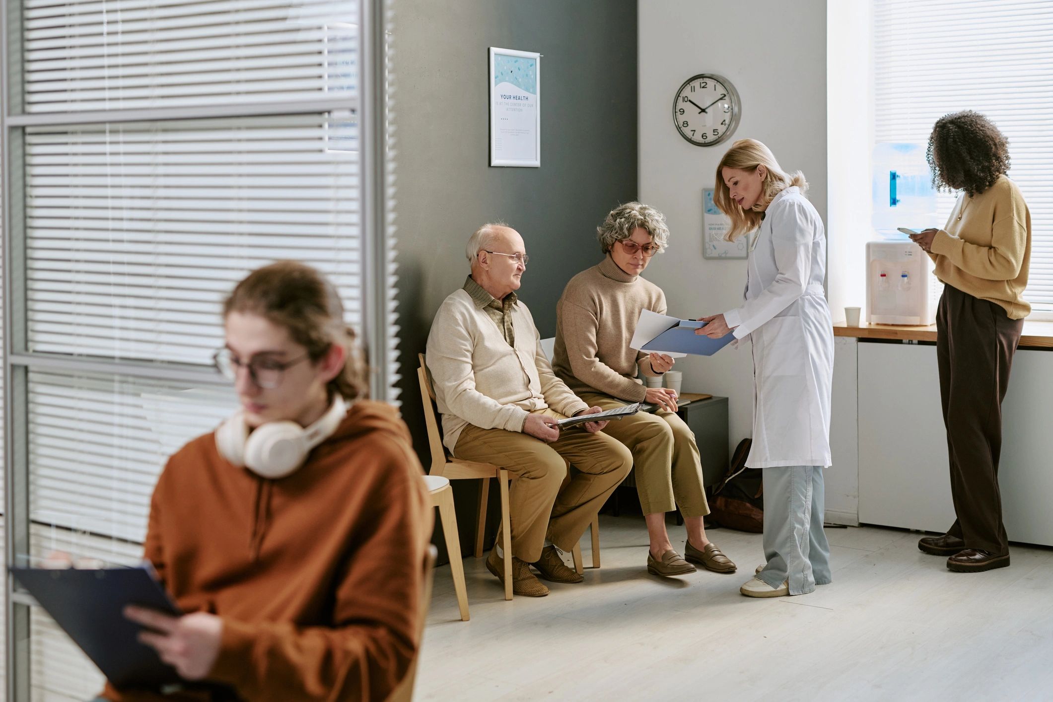 Doctor consulting patients in a clinic waiting area, representing premium patient experience